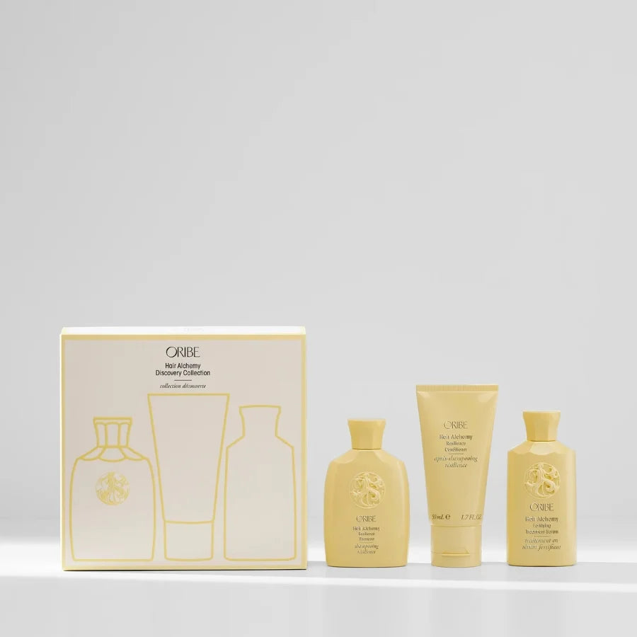 Oribe hair care products. Hair Alchemy Discovery Collection, including bottles and a box on a light gray background